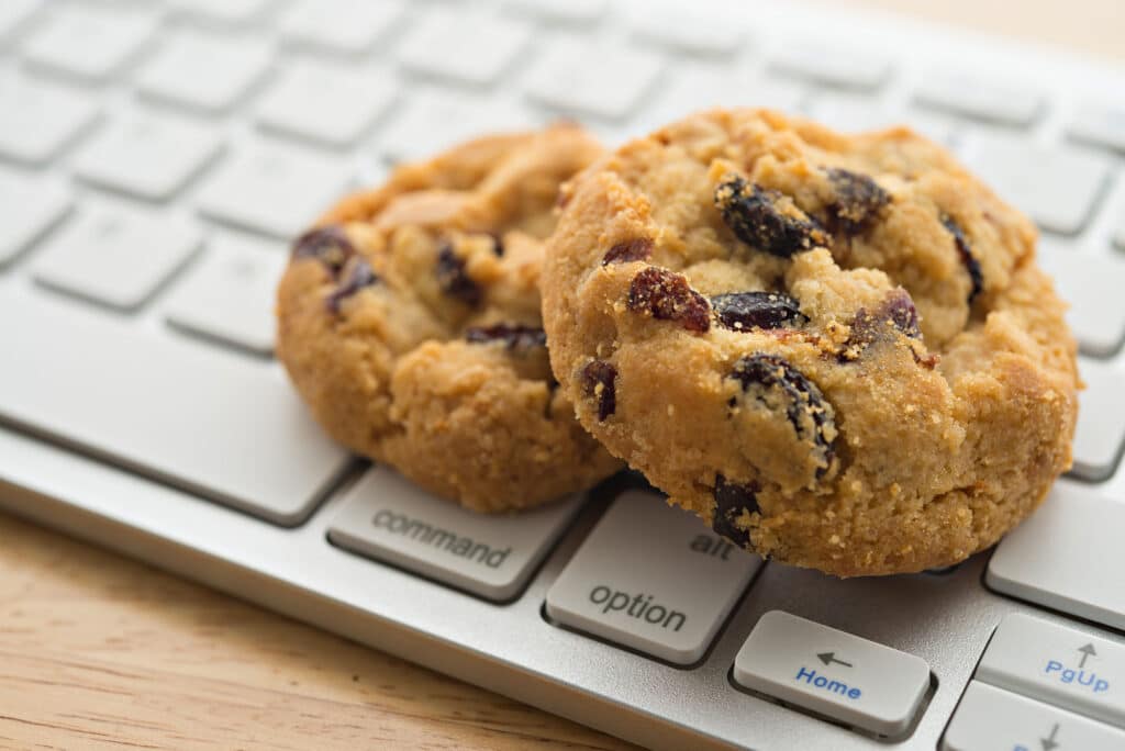 Freshly baked chocolate chip cookies on a computer keyboard