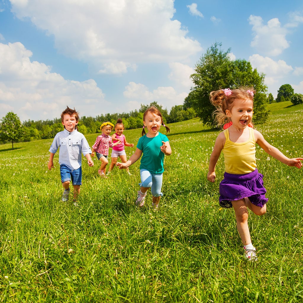 Children playing and running in a sunny park